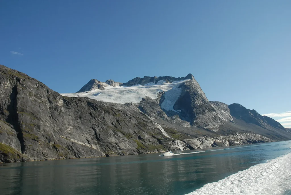 Rocky slopes and water in Nuuk fjord, photographed from a boat
